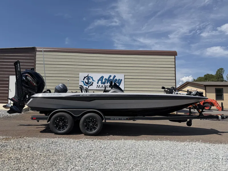 The Image of A black Skeeter ZXE20 boat from 2027 sits on a trailer in front of a building. - 1