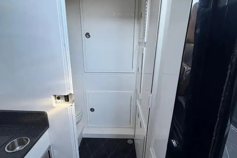 Slide: The Image of Interior of 2021 Concept 44' Open Deck boat with white cabinetry and black countertop. - 51