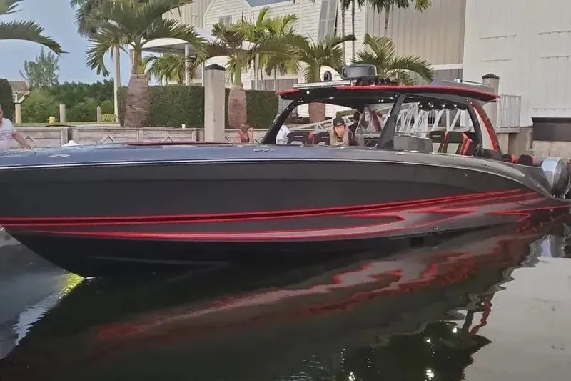 Slide: The Image of 2021 Concept 44' Open Deck boat with sleek black and red design, docked near palm trees. - 17