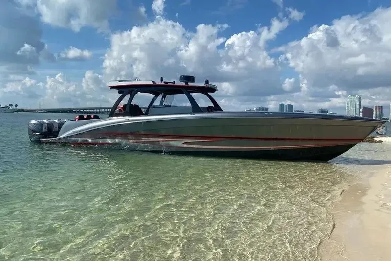 The Image of 2021 Concept 44' Open Deck boat on clear water near sandy shore, under blue sky. - 1