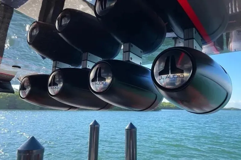 Slide: The Image of JL Audio speakers on a 2021 Concept 44' Open Deck boat, overlooking a serene lake. - 40