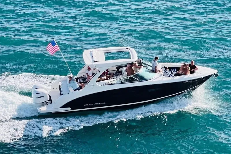 Slide: The Image of 2017 Regal 33 OBX boat cruising with passengers on blue ocean water. - 1