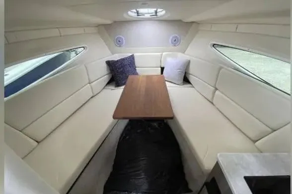 Slide: The Image of 2020 Regal 26 XO boat interior with plush seating and wooden table. - 30