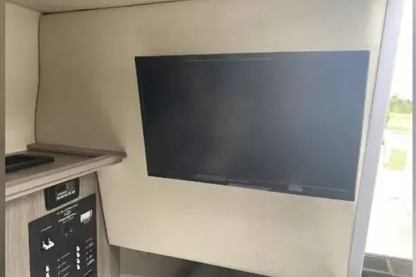 Slide: The Image of Interior of a 2020 Regal 26 XO boat featuring a mounted flat-screen TV. - 40