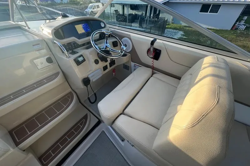 Slide: The Image of 2020 Regal 26 XO boat interior with steering wheel, navigation system, and beige seating. - 14