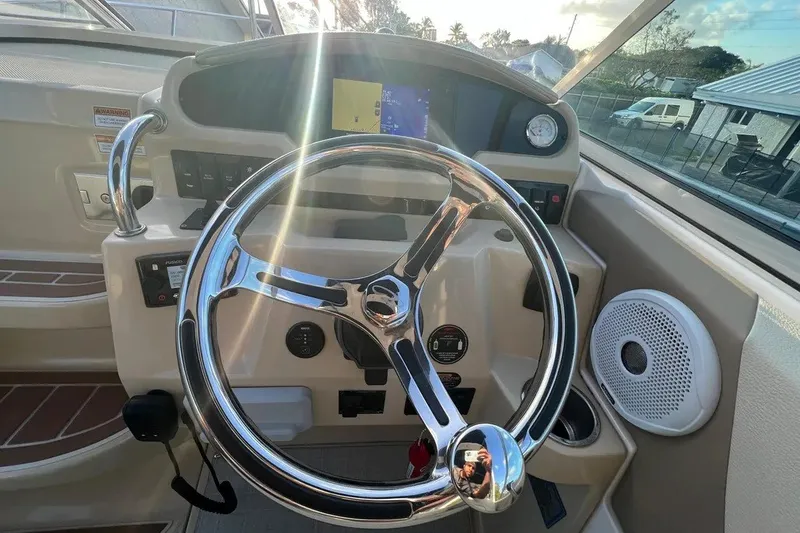 Slide: The Image of Steering wheel and dashboard of a 2020 Regal 26 XO boat, featuring modern controls. - 17