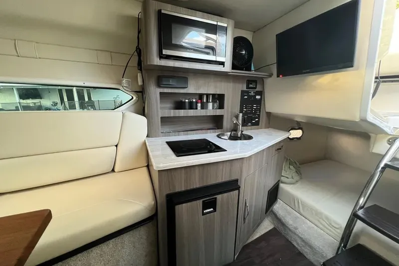 Slide: The Image of Interior of 2020 Regal 26 XO boat with kitchenette, seating, and TV. - 35