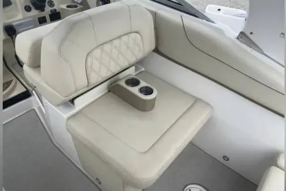 Slide: The Image of 2020 Regal 26 XO boat interior with beige seating and dual cup holders. - 24