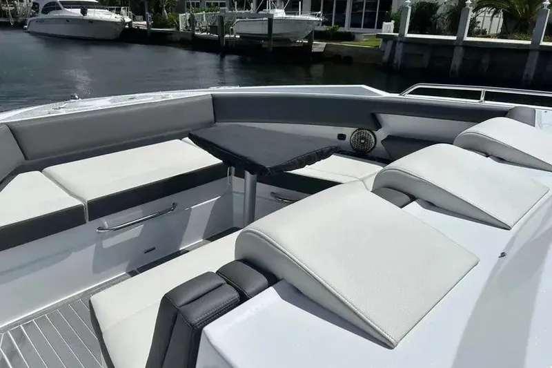 Slide: The Image of 2023 Cruisers Yachts 38 GLS OB interior with cushioned seating and table, docked by the water. - 9