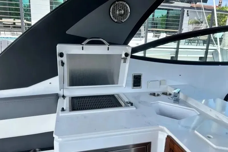 Slide: The Image of Outdoor kitchen area on 2023 Cruisers Yachts 38 GLS OB, featuring grill and sink. - 14