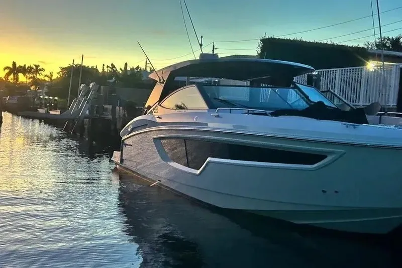 Slide: The Image of 2023 Cruisers Yachts 38 GLS OB at sunset, docked in a serene waterfront setting. - 21