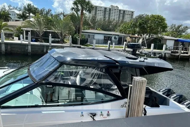 Slide: The Image of 2023 Cruisers Yachts 38 GLS OB docked near waterfront homes, showcasing sleek design. - 3