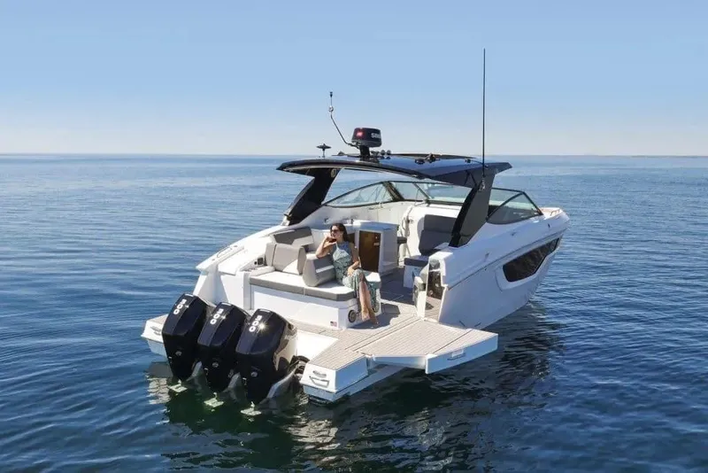 Slide: The Image of 2023 Cruisers Yachts 38 GLS OB on calm water, featuring triple outboard engines. - 6