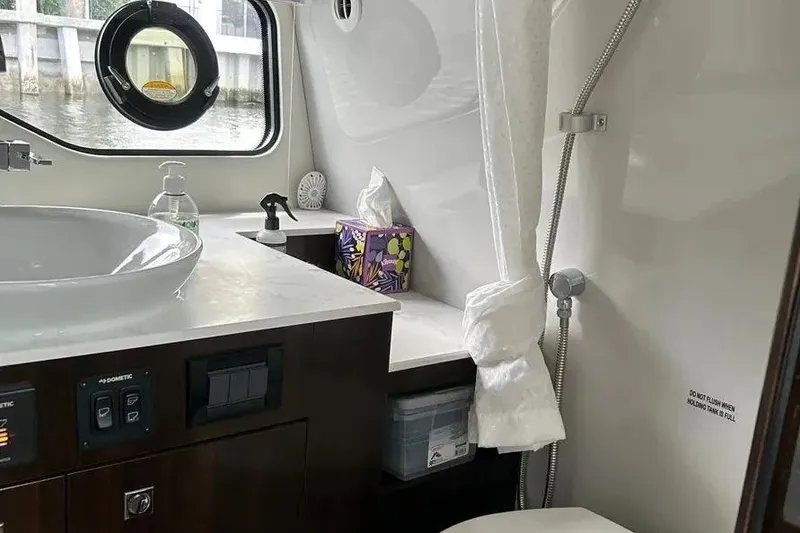 Slide: The Image of 2023 Cruisers Yachts 38 GLS OB bathroom with sink, shower, and porthole window. - 28