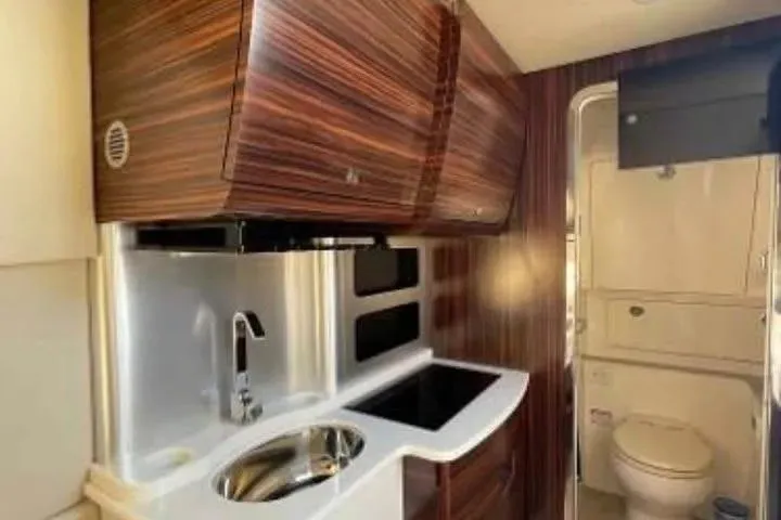 Slide: The Image of Luxurious 2019 Scout 420 LXF yacht interior with modern kitchenette and bathroom. - 21