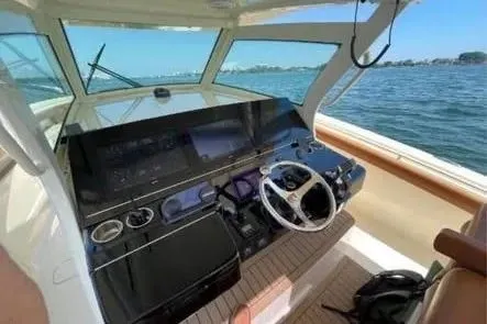Slide: The Image of 2019 Scout 420 LXF boat helm with modern controls on open water. - 14