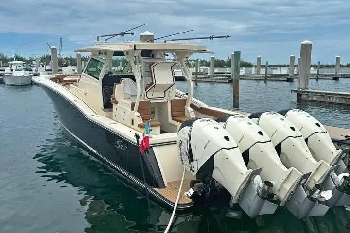Slide: The Image of 2019 Scout 420 LXF boat docked with four powerful outboard engines. - 3