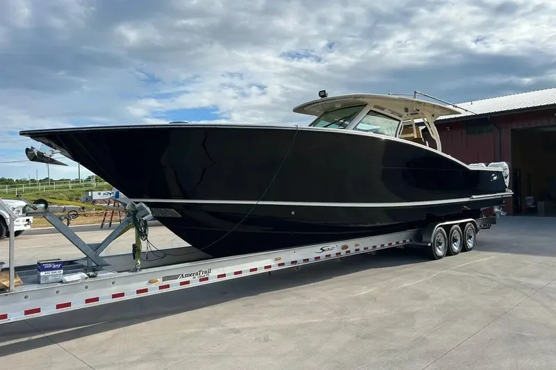 Slide: The Image of 2019 Scout 420 LXF boat on trailer under cloudy sky. - 6