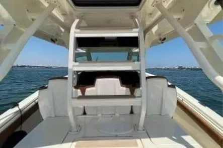 Slide: The Image of 2019 Scout 420 LXF boat interior with seating, ocean view, and clear sky. - 13