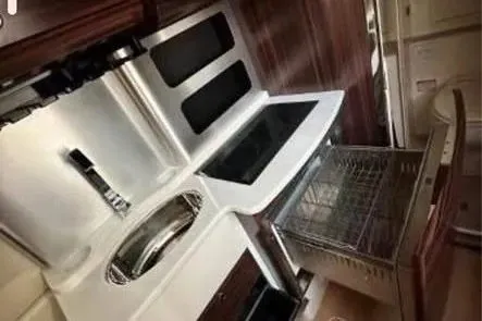 Slide: The Image of 2019 Scout 420 LXF boat interior kitchen with modern appliances and sleek design. - 23