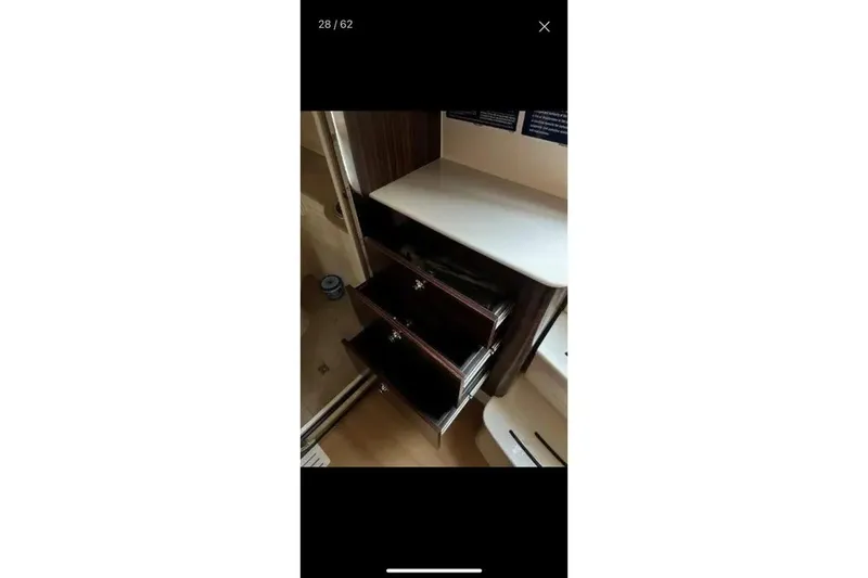 Slide: The Image of Interior view of 2019 Scout 420 LXF boat with open wooden drawers. - 37
