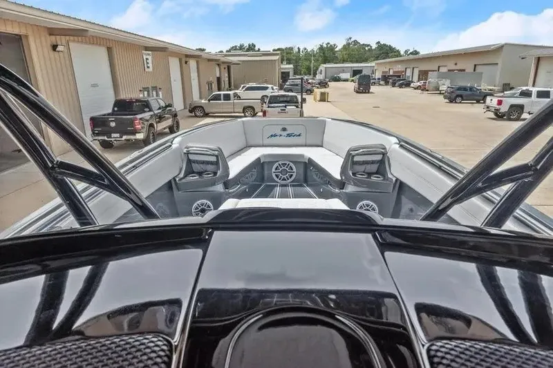 Slide: The Image of 2023 Nor-Tech 390 Center Console boat at a marina with parked vehicles. - 8