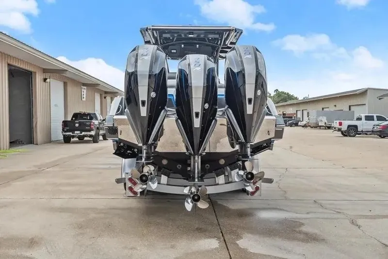 Slide: The Image of 2023 Nor-Tech 390 Center Console with quad engines, parked in an industrial area. - 2