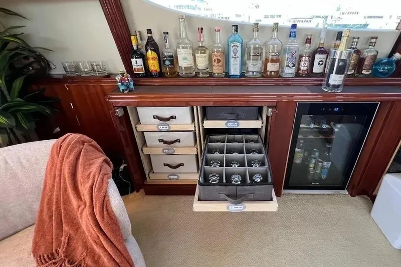 Slide: The Image of Luxurious 2004 Lazzara SC Motor Yacht bar with liquor bottles, glass storage, and mini fridge. - 54