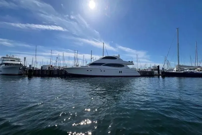Slide: The Image of 2004 Lazzara SC Motor Yacht docked in a sunny marina, surrounded by sailboats. - 78