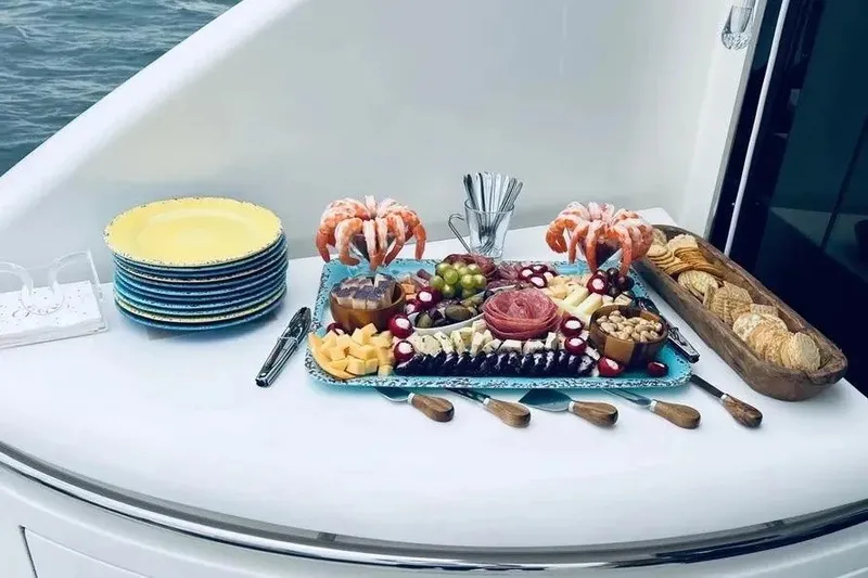 Slide: The Image of Elegant charcuterie spread on 2004 Lazzara SC Motor Yacht, featuring shrimp, cheese, and crackers. - 58