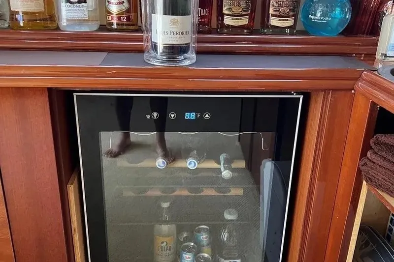 Slide: The Image of Luxury yacht bar with wine cooler, featuring various spirits and beverages. Lazzara SC Motor Yacht, 2004. - 55
