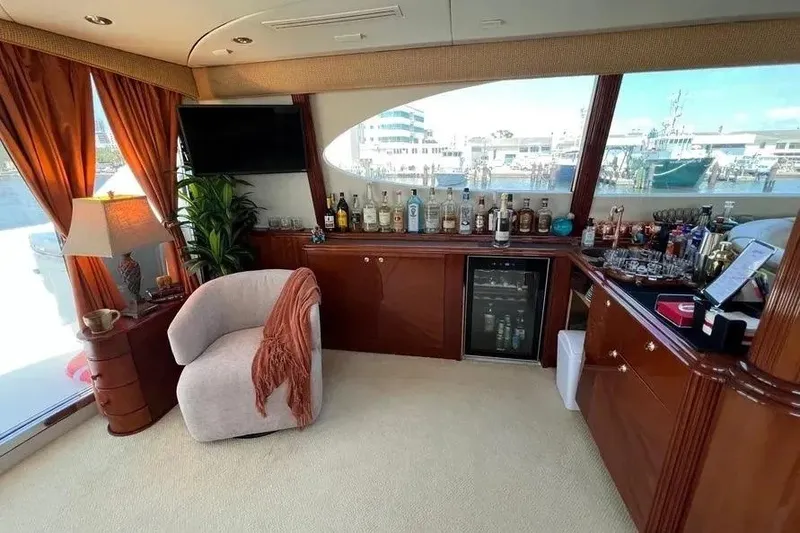 Slide: The Image of Luxurious 2004 Lazzara SC Motor Yacht interior with bar, plush seating, and scenic window view. - 52