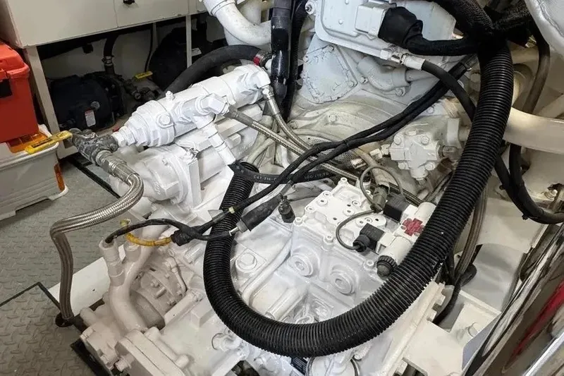Slide: The Image of Engine room of a 2004 Lazzara SC Motor Yacht, showcasing intricate machinery and hoses. - 73