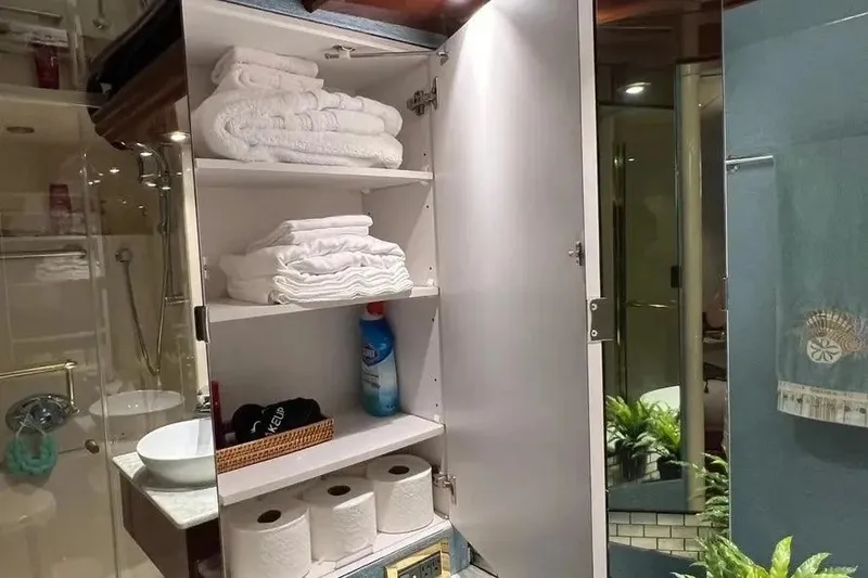 Slide: The Image of Bathroom cabinet on 2004 Lazzara SC Motor Yacht with towels and toiletries. - 41