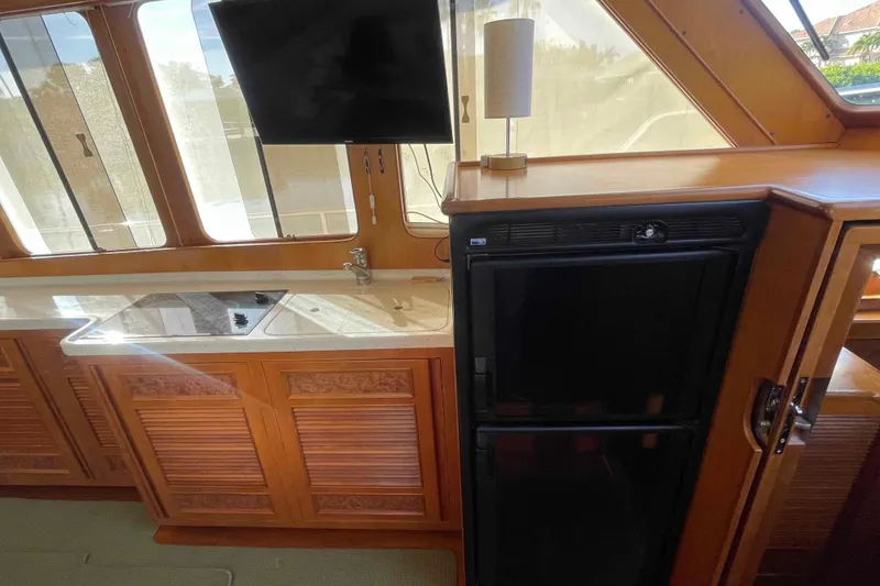 Slide: The Image of Interior of 2002 President Trawler with kitchenette, sink, stove, and refrigerator. - 52