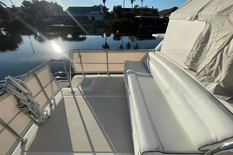 Slide: The Image of 2002 President Trawler deck with seating, overlooking serene waterfront view. - 27