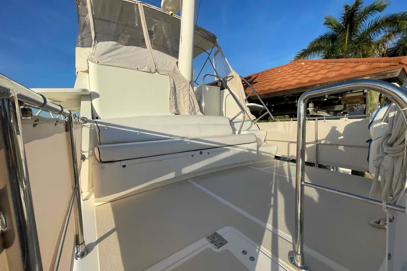 Slide: The Image of 2002 President Trawler deck with seating, stainless steel railings, and clear blue sky. - 26