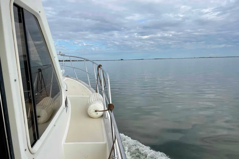 Slide: The Image of 2002 President Trawler cruising on calm waters under a cloudy sky. - 116