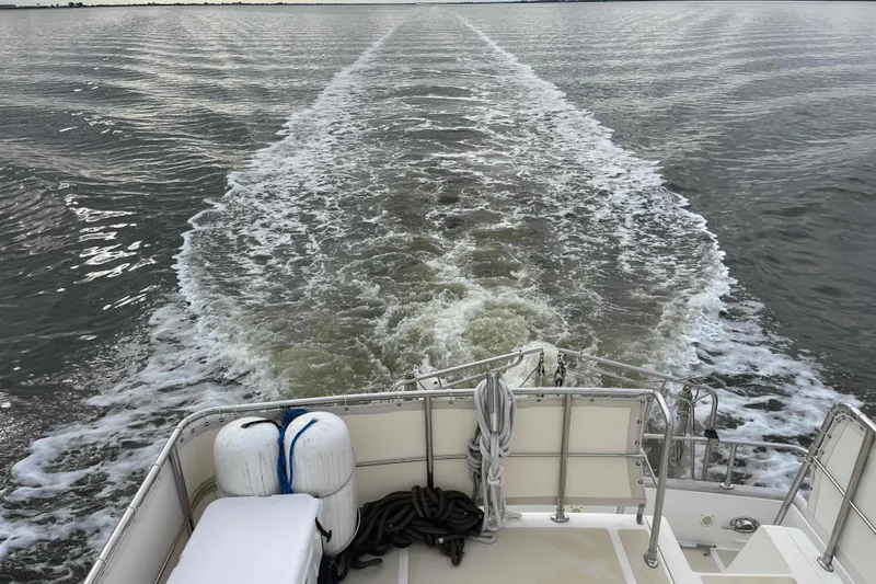Slide: The Image of Wake trail behind 2002 President Trawler on open water. - 117