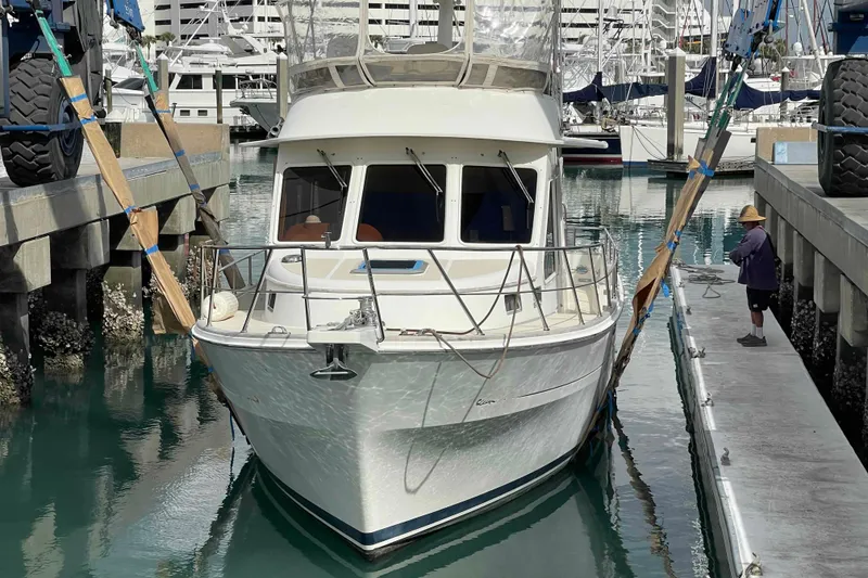 Slide: The Image of 2002 President Trawler in marina, secured with straps, surrounded by water and docks. - 111
