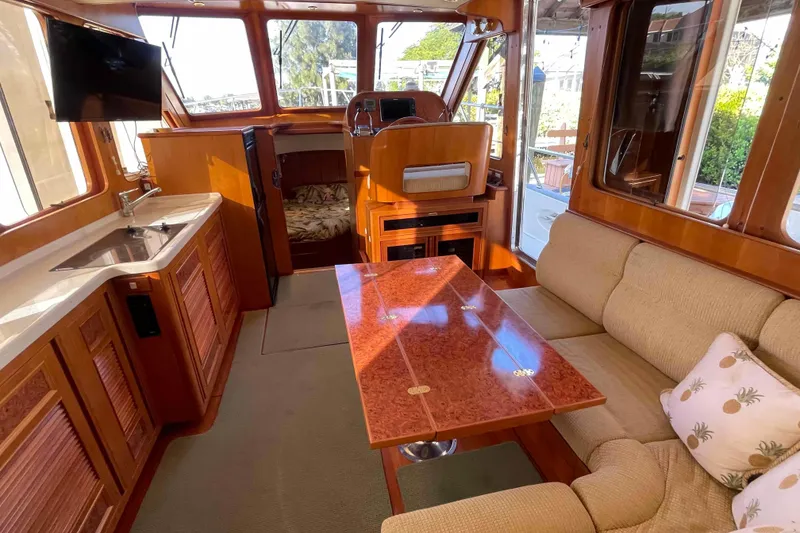 Slide: The Image of Luxurious 2002 President Trawler interior with cozy seating, dining table, and kitchenette. - 36