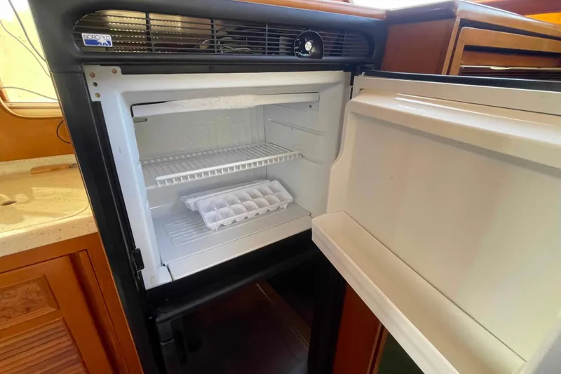 Slide: The Image of Open refrigerator in 2002 President Trawler yacht with ice tray and wooden cabinetry. - 53