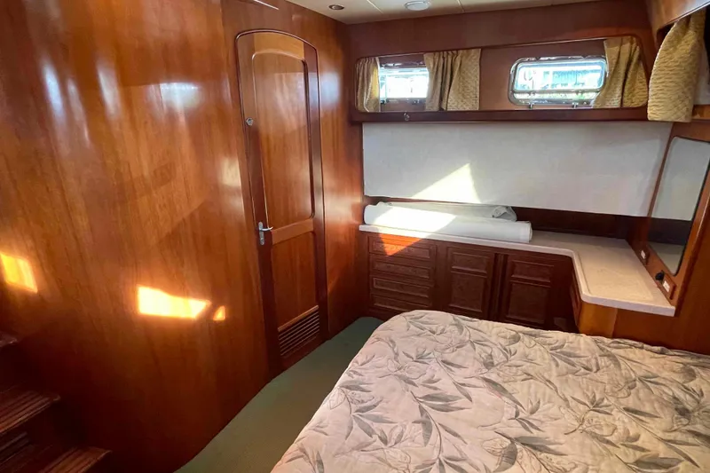 Slide: The Image of Luxurious 2002 President Trawler cabin with wood paneling and cozy bedding. - 67