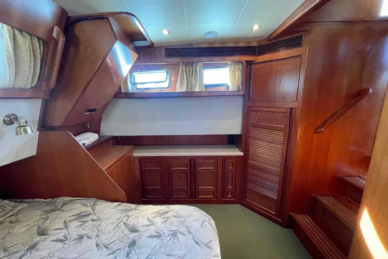 Slide: The Image of Luxurious 2002 President Trawler cabin with elegant wood paneling and cozy bedding. - 13