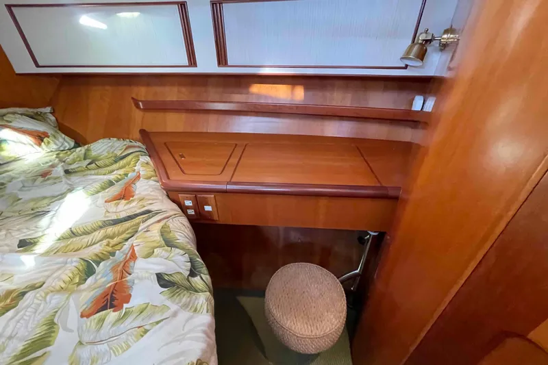 Slide: The Image of Cozy cabin interior of 2002 President Trawler with wooden desk and tropical bedding. - 60