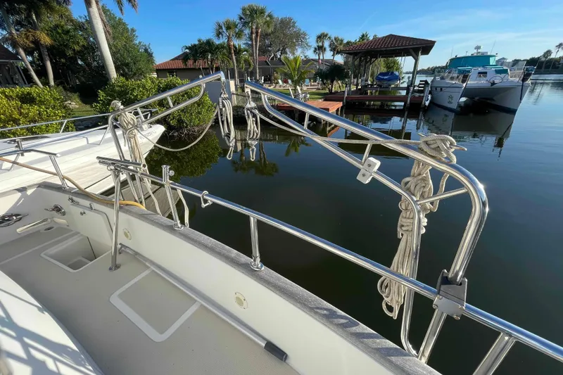 Slide: The Image of 2002 President Trawler docked by a serene waterfront with lush greenery. - 23