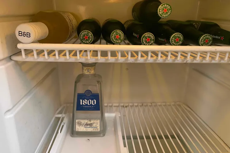Slide: The Image of Refrigerator with Heineken bottles and 1800 Tequila on a 2002 President Trawler. - 55