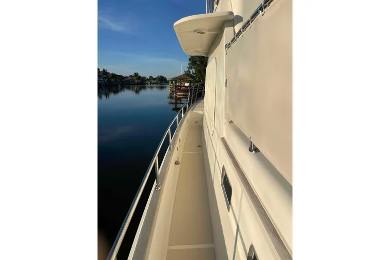 Slide: The Image of 2002 President Trawler yacht deck with serene waterfront view. - 29