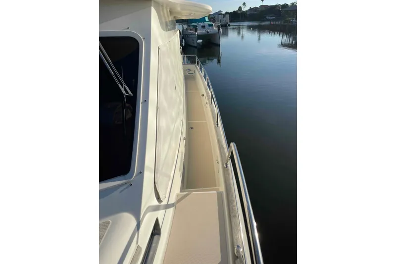 Slide: The Image of 2002 President Trawler yacht deck with railing, docked by calm waters. - 22