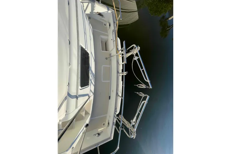 Slide: The Image of 2002 President Trawler boat deck with railing, docked on calm water. - 25